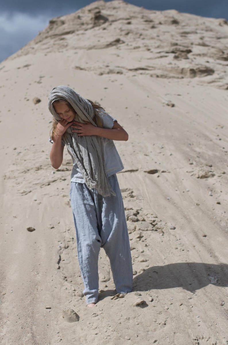 KnockKnockLinen “Silence” short-sleeve linen top—light grey, buttoned front, loose fit—shown on model outdoors with a long natural-flax linen scarf and relaxed linen pants against a sandy backdrop. Linen blouse / buttoned linen top.
