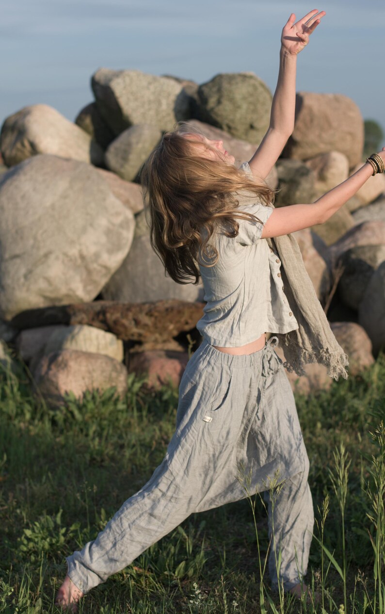 KnockKnockLinen short-sleeve buttoned linen top “Silence” — light grey, round neck, front button placket, loose fit — shown on model outdoors with matching drawstring linen pants and a fringed scarf. Summer linen blouse on model.