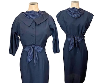 May include: Two navy blue dresses with white polka dot accents. One dress has a collar and three-quarter sleeves, while the other has a sleeveless design. Both dresses feature a bow at the waist.