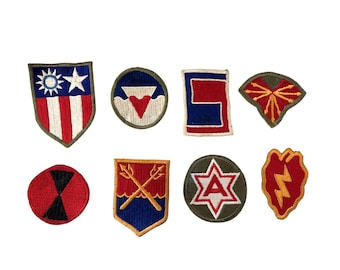 Könnte beinhalten: Eine Sammlung von acht gestickten Aufnähern mit verschiedenen militärischen Designs. Die Aufnäher weisen eine Reihe von Farben auf, darunter Rot, Blau, Grün und Gold, und zeigen Sterne, Streifen und andere Embleme. Die Aufnäher sind wahrscheinlich für Uniformen oder Sammlerstücke.