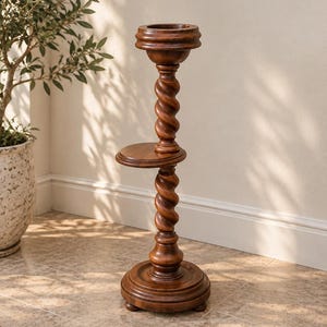 May include: A dark brown wooden plant stand featuring a circular top, a middle shelf, and a base, all connected by two vertically stacked, spiralled, twisted columns. The structure is supported by small, rounded feet at the bottom of the base.