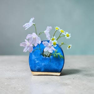 Jarrón de cerámica Hagi: esmalte azul brumoso, textura de arcilla suave, marcas de cocción naturales, 30% de descuento.
