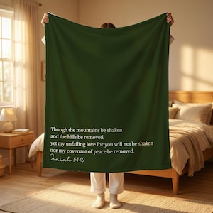 May include: A dark green blanket with white text from Isaiah 54:10. The text reads, "Though the mountains be shaken and the hills be removed, yet my unfailing love for you will not be shaken nor my covenant of peace be removed."