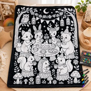 May include: A black and white throw blanket featuring a forest scene with a fox, rabbit, deer, bear, squirrel, and hedgehog sitting around a table with a cake and tea cups. The design includes trees, flowers, lanterns, and a crescent moon.