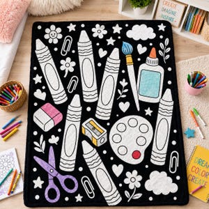 May include: A rectangular black blanket featuring a white outline pattern of art supplies including crayons, a paintbrush, a glue bottle, a pencil sharpener, a paint palette, scissors, an eraser, paper clips, flowers, stars, and clouds.
