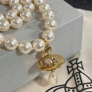 May include: A white ceramic mug with a black handle and the text "But First, Coffee" in a black, bold font. The mug is on a white surface.