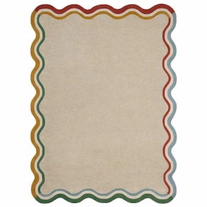 May include: Rectangular area rug with a neutral beige center and a wavy border. The border features a repeating pattern of red, yellow, green, and blue stripes. The rug has a soft, textured appearance, suitable for home decor.
