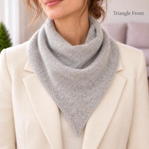 May include: A light gray triangular scarf with a textured knit pattern worn around the neck. The scarf features a pointed front design. The text Triangle Front is visible in the upper right corner of the image. The scarf is worn over a white blazer.