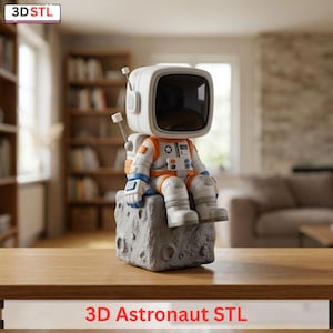 May include: A white and orange astronaut figurine with a TV-shaped helmet sits on a gray, textured moon-like base. The astronaut is wearing a spacesuit with blue and white accents. The image includes the text "3D Astronaut STL".