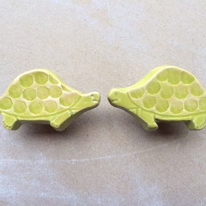 May include: Two green ceramic turtle drawer pulls with a textured shell design.