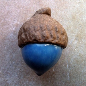 Peut inclure: Une décoration d'écureuil en céramique avec un dessus brun et un dessous glacé bleu.