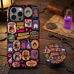 May include: A black smartphone case and a matching circular phone grip featuring a colorful collage of Dungeon Crawler Carl themed stickers, including illustrations of a cat wearing a crown, a dinosaur, pink donuts, and text like NEEEEEW ACHIEVEMENT.