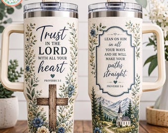 Może przedstawiać: Dwa kremowe kubki ze stali nierdzewnej z uchwytami i przezroczystymi pokrywkami. Lewy kubek posiada drewniany krzyż, motywy kwiatowe oraz tekst Trust in the Lord with all your heart Proverbs 3:5. Prawy kubek przedstawia kościół, góry oraz tekst Lean on him in all your ways and he will make your paths straight Proverbs 3:6.