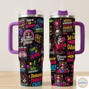 May include: Two stainless steel tumblers with purple lids and handles, featuring a black background covered in colorful graphics of cats, dinosaurs, treasure chests, and trophies, with text including Princess Posse and This Is An Outrage.