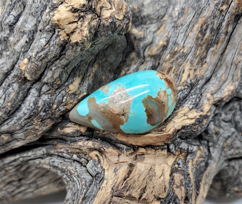 Pu&ograve; includere: Un cabochon di turchese a forma di lacrima con un colore blu-verde e una matrice marrone. La pietra &egrave; liscia e lucidata.