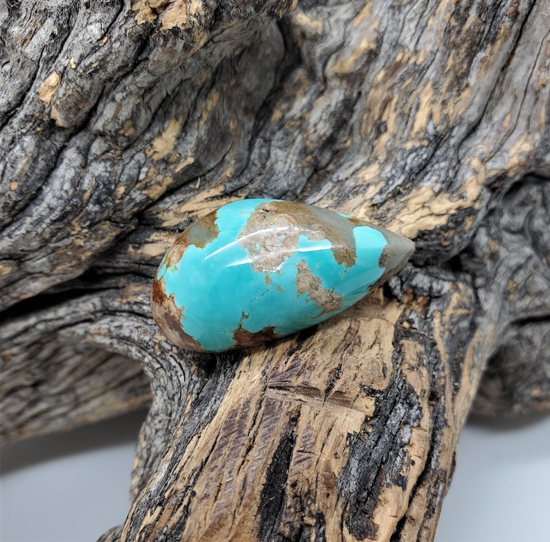 Pu&ograve; includere: Un cabochon di turchese a forma di lacrima con matrice marrone. Il turchese &egrave; di un colore blu-verde vibrante e la matrice &egrave; di un colore marrone scuro.