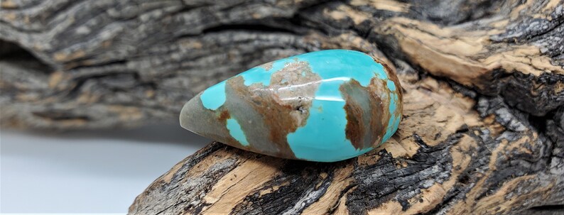 Pu&ograve; includere: Un cabochon di turchese a forma di lacrima con matrice marrone. Il turchese &egrave; di un colore blu-verde vibrante.