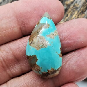 Pu&ograve; includere: Un cabochon di turchese a forma di lacrima con matrice marrone. Il turchese &egrave; di un colore blu-verde vibrante.