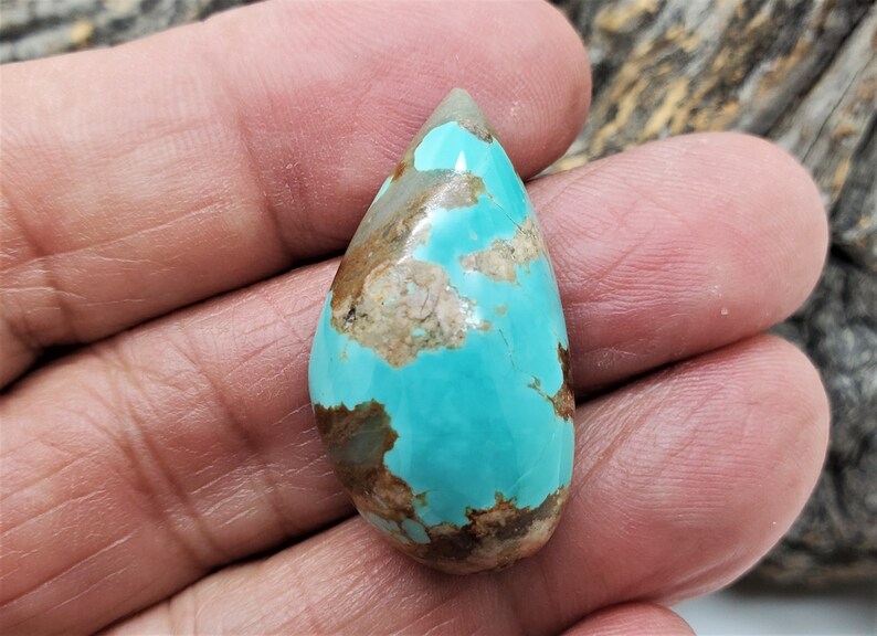 Pu&ograve; includere: Un cabochon di turchese a forma di lacrima con matrice marrone. Il turchese &egrave; di un colore blu-verde vibrante.