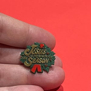 Pin de solapa vintage con corona navideña "Jesús es la razón" – Acebo, lazo rojo, letras doradas