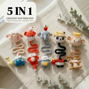 Może przedstawiać: Kolekcja pięciu szydełkowych zabawek ze zwierzętami, w tym owca, lis, słoń, panda i małpa. Każda zabawka ma unikalny design i schemat kolorów, z długimi, teksturowanymi szyjami. Zabawki są ułożone na jasnej powierzchni.