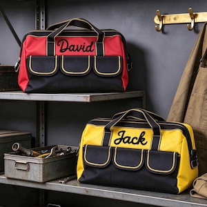 May include: Two rectangular tool bags with black handles and three front pockets. One bag is red with the name David in black script, and the other is yellow with the name Jack in black script. Both bags feature black trim and yellow piping.