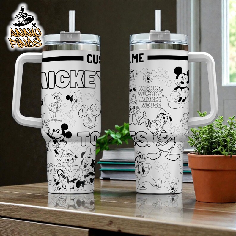 two large, white, and colorful tumblers with Disney characters printed on them, placed on a wooden surface next to a potted plant.