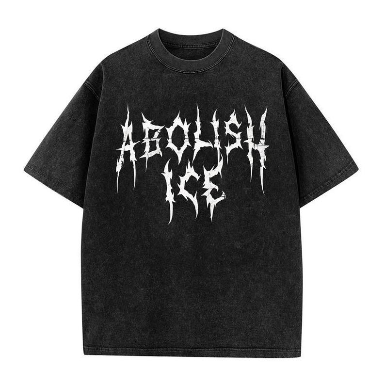 May include: Black t-shirt with the white text "ABOLISH ICE" in a gothic font. The shirt has a vintage, washed-out appearance. The short-sleeved tee is a casual wear item.