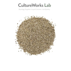 Puede incluir: Un montón de material granular marrón claro, posiblemente vermiculita, sobre un fondo blanco. El texto "CultureWorks Lab" está en la parte superior, con el lema "Mycology Supplies | Liquid Cultures | Lab Quality" debajo.