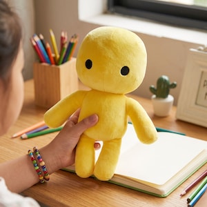 Può includere: Una bambola di peluche giallo brillante con una testa liscia e arrotondata e due piccoli occhi circolari neri. Il giocattolo presenta una forma umanoide semplice con due braccia e due gambe, realizzato in un tessuto morbido e uniforme.