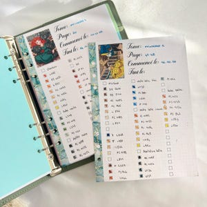May include: Open planner with two pages featuring colorful illustrations and handwritten notes. The pages include character images and color swatches with corresponding codes. The planner is bound with a teal cover and decorative washi tape.