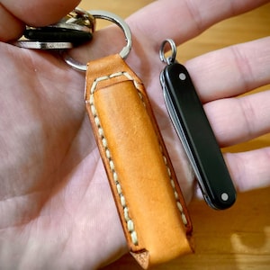 Pode incluir: Um conjunto de três canecas de cerâmica creme com esmalte salpicado. Cada caneca apresenta um design floral pintado à mão em tons de azul, verde e amarelo. As canecas têm uma forma simples e arredondada e uma pega confortável.