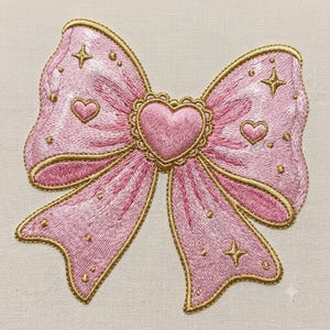 Könnte beinhalten: Ein gestickter Aufnäher in Form einer rosa Schleife mit einem zentralen Herz-Emblem und einem gewellten Goldrand. Die Schleife ist mit kleinen gestickten goldenen Sternen und Herzmotiven verziert, die alle mit goldenem Metallic-Garn auf hellem Stoff umrandet sind.
