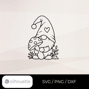 May include: A black and white line art illustration of a gnome wearing a tall hat with a heart detail and a pom-pom, holding a spotted mushroom. The design includes small leafy sprigs at the base and the text Silhouette SVG PNG DXF.