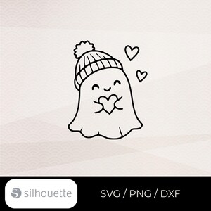May include: A black and white line art illustration of a ghost wearing a pom-pom beanie, holding a heart, with two additional floating hearts nearby. The text SVG / PNG / DXF appears in the bottom right corner next to a logo.