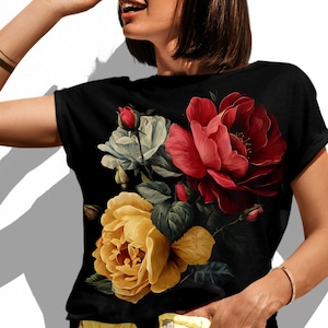 May include: A black short-sleeved t-shirt featuring a large, detailed floral graphic on the front. The design displays a cluster of blooming flowers in vibrant shades of deep red, golden yellow, and soft white, accented by green leaves.