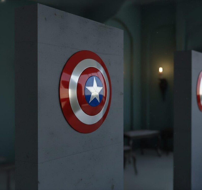 May include: A Captain America shield, featuring a red outer ring, silver concentric circles, and a blue center with a white star. The shield is mounted on a gray rectangular structure, with a blurred background.