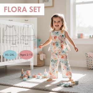 May include: A young child wearing a floral print top and pants set. The outfit has a peplum top and wide-leg pants. The image includes the text "FLORA SET" and a diagram of the outfit. The size range is XS-2XL and ages 2-13.