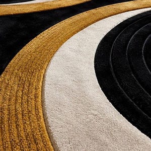 Pode incluir: Um tapete felpudo com um padr&atilde;o geom&eacute;trico arrojado de c&iacute;rculos conc&ecirc;ntricos e curvas amplas. O design consiste em sec&ccedil;&otilde;es de preto profundo, amarelo mostarda quente e branco creme com uma superf&iacute;cie texturizada de pelo alto.