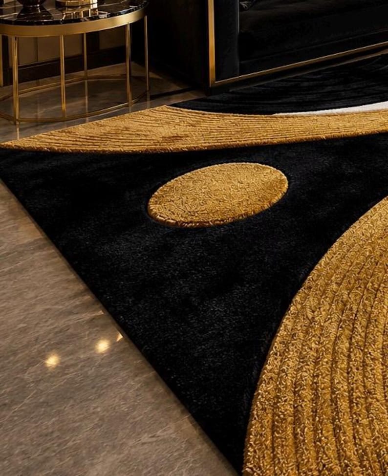 Pode incluir: Um tapete de pel&uacute;cia com um fundo preto profundo e padr&otilde;es texturizados em dourado contrastante. O design inclui uma forma oval dourada central proeminente e sec&ccedil;&otilde;es douradas curvas com uma textura de superf&iacute;cie nervurada em relevo.
