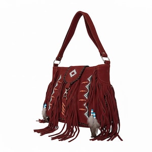 May include: A burgundy suede shoulder bag with long fringe and a matching strap. The bag features decorative beading, a diamond-shaped flap, and dangling feathers. The bag has a bohemian or Southwestern style.