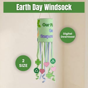 May include: A cylindrical Earth Day windsock with green, blue, and white streamers. The windsock has the text "Our Planet, Our Responsibility" and is decorated with shamrocks, hearts, and recycling symbols. The words "Earth Day Windsock" are at the top.