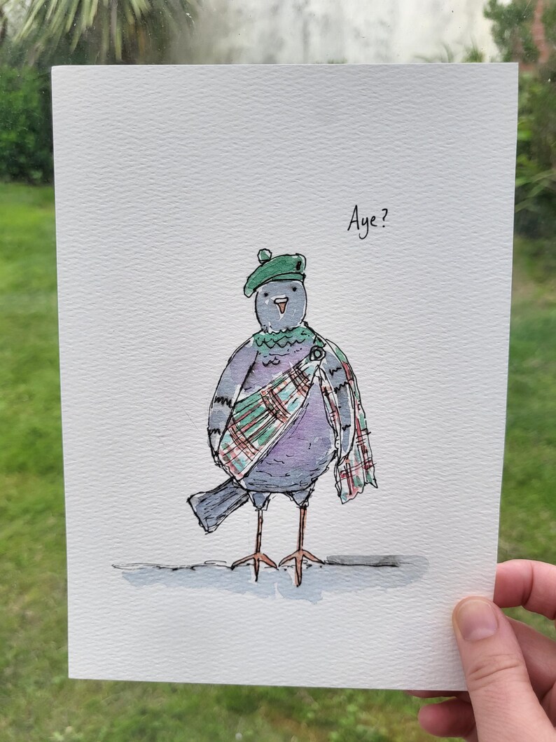 May include: A watercolor illustration on white paper featuring a grey pigeon wearing a green beret and a red, green, and white plaid sash. The pigeon has a small orange beak and is standing on a grey line. The text "Aye?" is written in black ink.