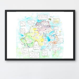May include: A framed watercolor map of Northern Ireland, featuring colorful regions and speech bubbles with phrases like "Keep 'er lit" and "What's the craic?". The map is set against a light blue and green watercolor wash.