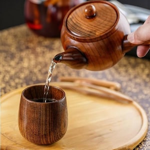 Puede incluir: Un juego de tres tazas de cerámica con un acabado moteado y mate. Las tazas son de color crema, gris claro y gris oscuro. Cada taza tiene un diseño simple y moderno y un asa redondeada.