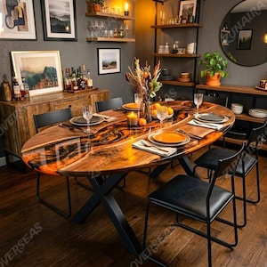 Puede incluir: Una mesa de comedor ovalada con un tablero de madera de borde natural y una incrustación central de resina color ámbar, sostenida por una base de metal negro en forma de X. La mesa está dispuesta con platos, cristalería y un centro de mesa.