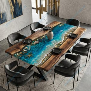 Könnte beinhalten: Ein rechteckiger Esstisch aus Holz mit einem blauen Epoxidharz-Mittelteil, der einer Strandszene mit Muscheln und Seesternen ähnelt. Der Tisch ist von sechs grauen Stühlen umgeben.