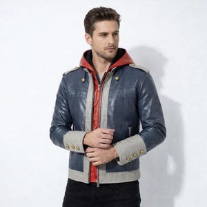 May include: A navy blue leather jacket with a red hood and lining. The jacket features gray accents, gold buttons, and a zipper closure. The sleeves have gray cuffs with gold buttons. A stylish outerwear piece.