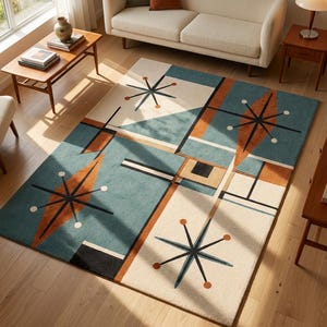 May include: A rectangular area rug featuring a geometric pattern with teal, cream, and burnt orange blocks. The design includes black starburst motifs with circular accents, straight black lines, and solid color shapes arranged in a grid-like layout.