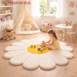 May include: A large, daisy-shaped rug with white petals and a yellow center. The rug is placed on a wooden floor in a child's playroom. A young girl in a yellow dress is playing with wooden blocks on the rug.